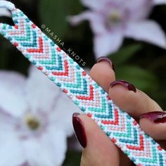 a woman's hand holding a colorful bracelet