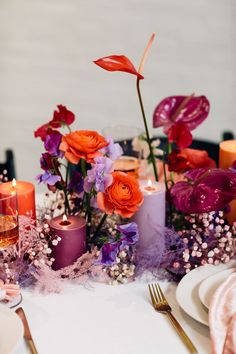 the table is set with candles, flowers and other things to decorate it for dinner