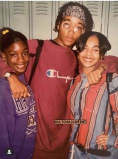 three young people standing next to each other in front of lockers with their arms around one another