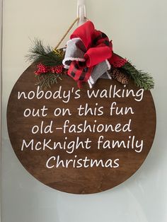 a wooden sign hanging from the side of a wall with words written on it and christmas decorations