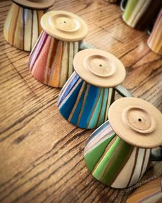 several different colored striped buttons sitting on top of a wooden table next to each other