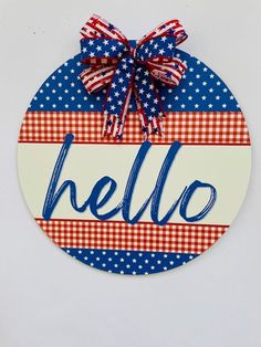 a red, white and blue door hanger with the word hello painted on it