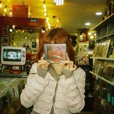 a woman holding up a cd in front of her face