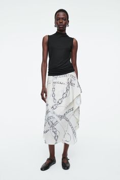 The contemporary chain pattern on this skirt works to highlight the asymmetric silhouette. The draped cloth wraps the waist and cascades from a gathered point at the left side. Cleanly finished with a pin hem, this detailed piece showcases our renowned attention to detail. Regular fitSide invisible zip fasteningA better alternative to conventional polyester, recycled polyester is made from pre‐ and post‐consumer waste Shell: 100% Recycled polyester. Excludes trims / Machine wash Back length of size EU 36 is 81.5cm / Model wears a size EU 36 Draped Cloth, Belted Cape, Culotte Shorts, Mens Cardigan Sweater, Chain Pattern, D P, Draped Skirt, Denim Sweater, Vest Shirt