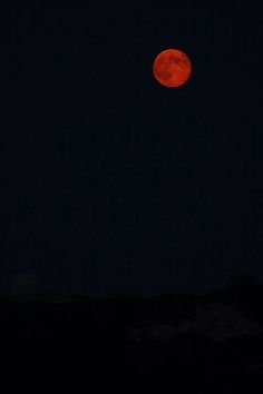 a red moon is seen in the night sky