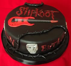 a birthday cake with a guitar and skull on it's side that says slipknot