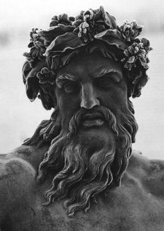 a black and white photo of a statue of a man with flowers on his head