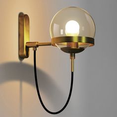 a wall light with a glass ball on the side and a black cord attached to it