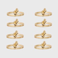 four gold rings with two hearts on each ring, and one has a knot in the middle