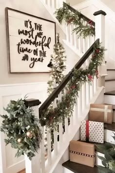 christmas decorations on the banisters and stairs in a home decorated with greenery