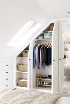 an attic bedroom with white walls and closets