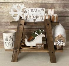 a wooden shelf filled with christmas decorations and other holiday items on top of a table