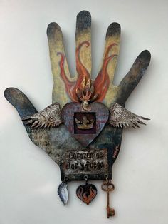 a hand with two wings holding a key and some other items on the inside of it