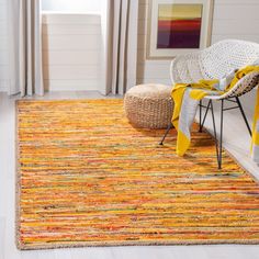 an area rug with yellow and orange colors in a living room next to a window