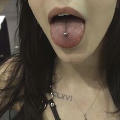 a close up of a person with a piercing on her tongue