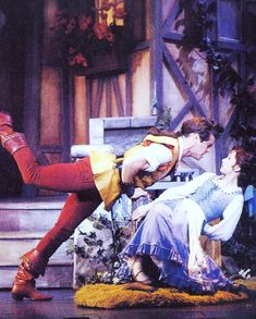 the actors are performing on stage in costumes and clothes with their legs spread out,