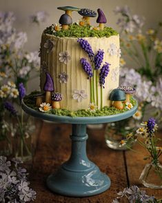 a cake decorated with flowers and mushrooms on a table