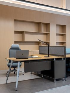 an empty office with two desks and a laptop on the table in front of it