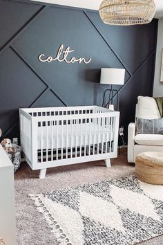 a baby's room with a white crib in the middle and a black wall behind it