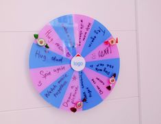 a colorful wheel with writing on it hanging from the side of a white tiled wall