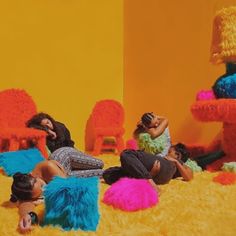 three women sitting on the floor in front of colorful furniture