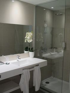 a white sink sitting under a bathroom mirror next to a bathtub and shower stall