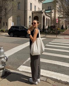 Girl posing in the crosswalk, wearing grey tailored pants, black vest, platform white converse, canvas tote bag , sunglasses, cute outfit, cute posing Thrifted Pants, Transition Outfits, White Converse, Canvas Tote Bag, Pants Black, Spring Summer Fashion, Canvas Tote, Converse, High Waist