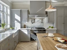 a kitchen with gray cabinets and wooden counter tops