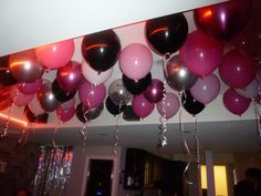 a room filled with balloons and streamers hanging from the ceiling