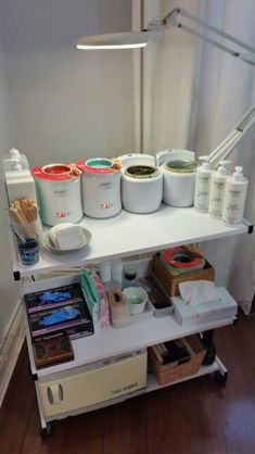 there is a shelf with many different items on it in the corner, including paint cans and brushes