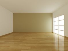 an empty room with hard wood floors and large windows