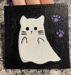 a painting of a white cat on a black background with paw prints in the foreground