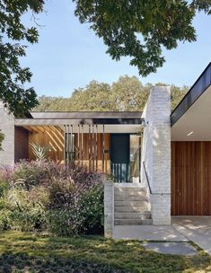 a modern house with stone steps leading up to the front door