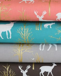 four different types of fabric with deer and trees on them, all in various colors