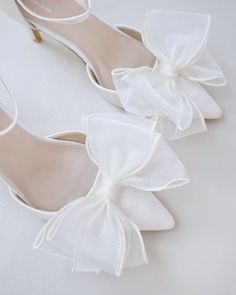 a pair of white shoes with bows on them