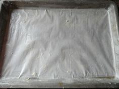 an uncooked baking pan with white paper on the top and bottom, ready to be baked