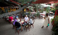 people sitting at tables in an outdoor restaurant