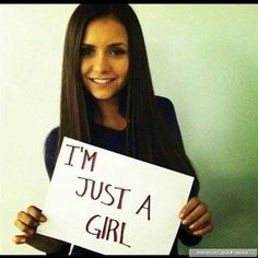 a woman holding a sign that says i'm just a girl