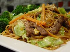 a white plate topped with noodles and veggies