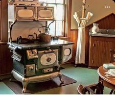 an old fashioned stove sitting in the middle of a kitchen