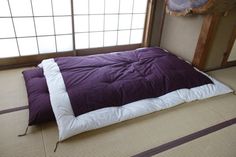 a bed that is in the middle of a room with tatami mats on it