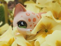 a close up of a cat figurine surrounded by flowers