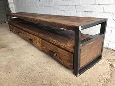 a large wooden box with metal handles on the bottom is sitting in front of a white brick wall