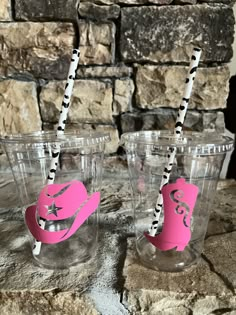 three plastic cups with straws in the shape of hats and stars are sitting on a stone table