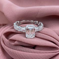 an emerald cut diamond ring with baguettes on top