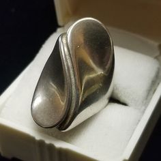 Vintage Sterling Silver Ring Modernist Designer Signed Unisex Size 5.5 US Large vintage abstract design Modernist sterling silver ring in very good vintage condition with age respective wear and patina, arrives gift boxed.  This is a stunning ring! Measures Approximately: 28 mm Wide (at center front area) 2.5 mm Wide (at center back) Weight:  8.5 Grams Hallmarks:  Sterling & Designer's $ Hallmark We do Combined Shipping Ask For a new invoice when finished shopping Mint - shows little to no indication of handling. Excellent - shows very minor evidence of handling. Very Good - shows evidence of wear and handling, with no major flaws. Good - shows moderate wear and is fully functional. Fair - shows moderate wear and has condition issues that may or may not be repairable. PLEASE READ All Props Vintage Silver Concave Ring, Vintage Silver Rings, Vintage Sterling Silver Rings, Cufflink Set, Vintage Rhinestone, Ring Box, Set Vintage, Rings Statement, Sterling Silber