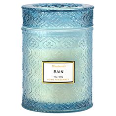 a blue glass jar with a label on the lid that says rain in front of it