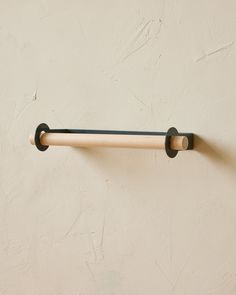 a wooden handle is attached to the wall with a metal bar on it's side