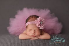 a baby girl wearing a pink tutu with a flower in her hair