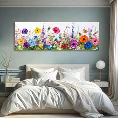 a bed with white sheets and colorful flowers on it